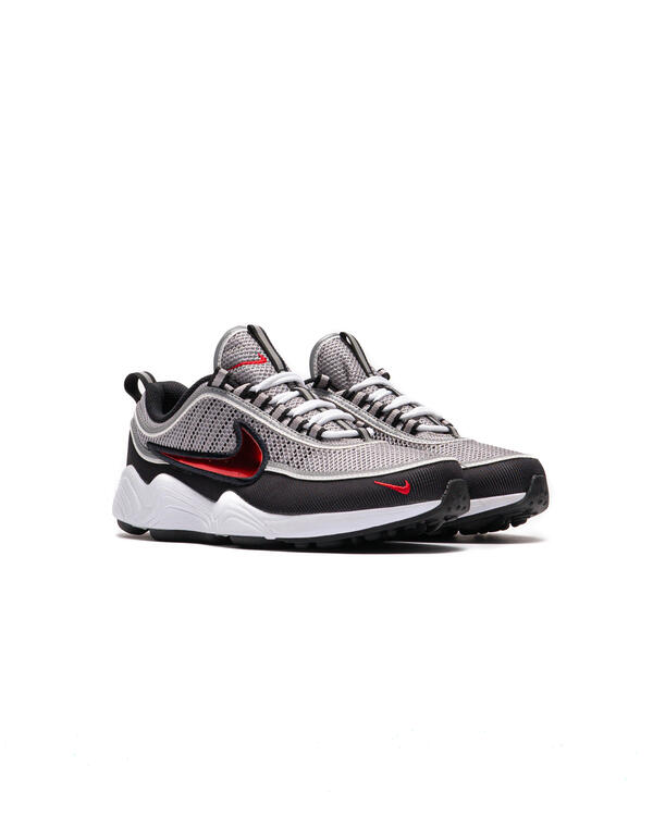 Running sneaker side view with metallic silver knit, black panels, red Swoosh, white sole