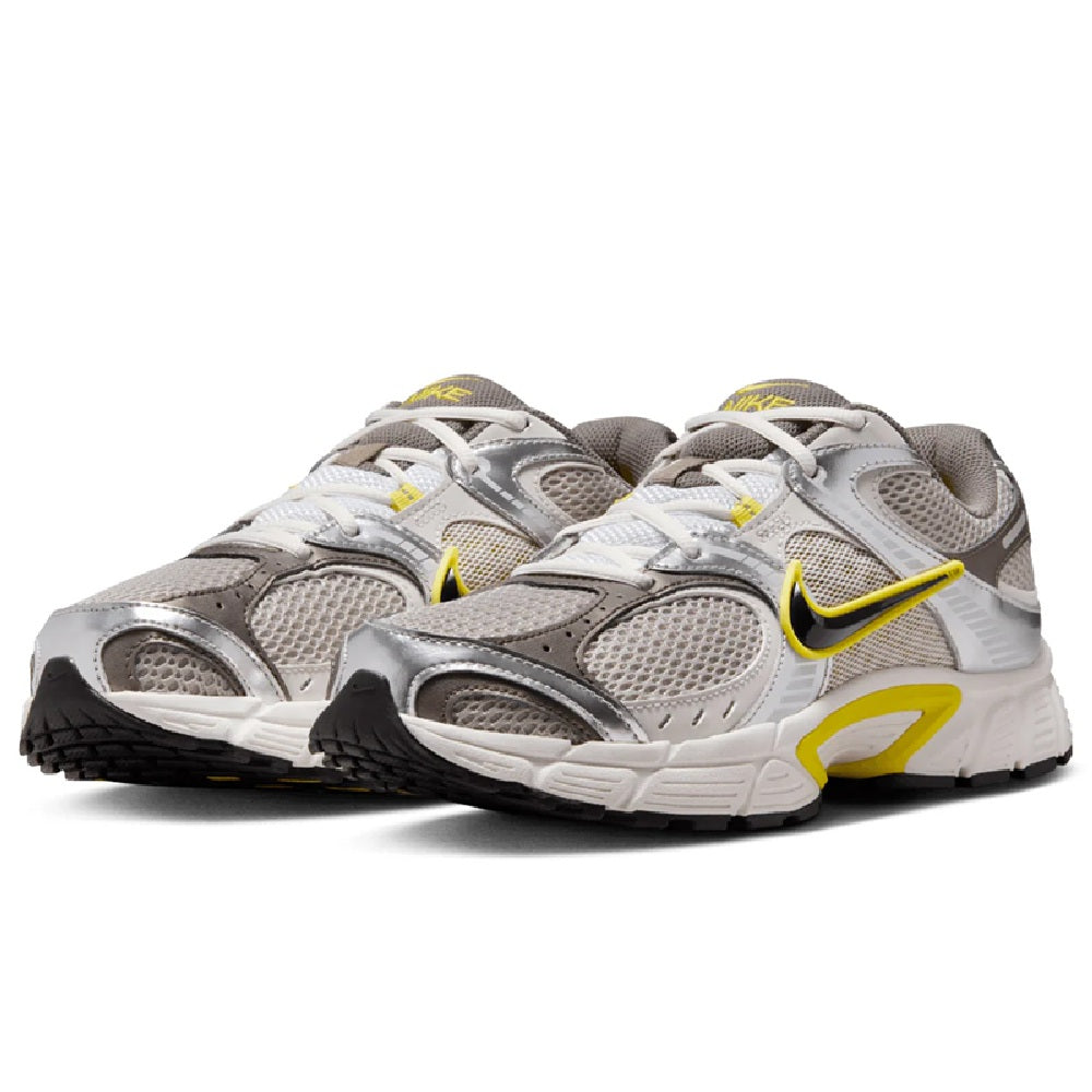 Nike running shoes, grey textile upper with lace-up front and yellow swoosh details.