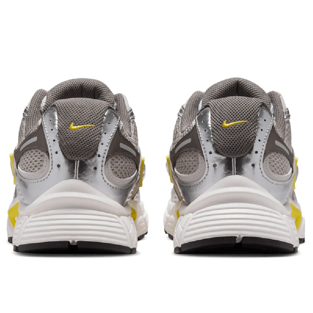 Pair of Nike running shoes in grey with yellow branding and white midsole, heel view.