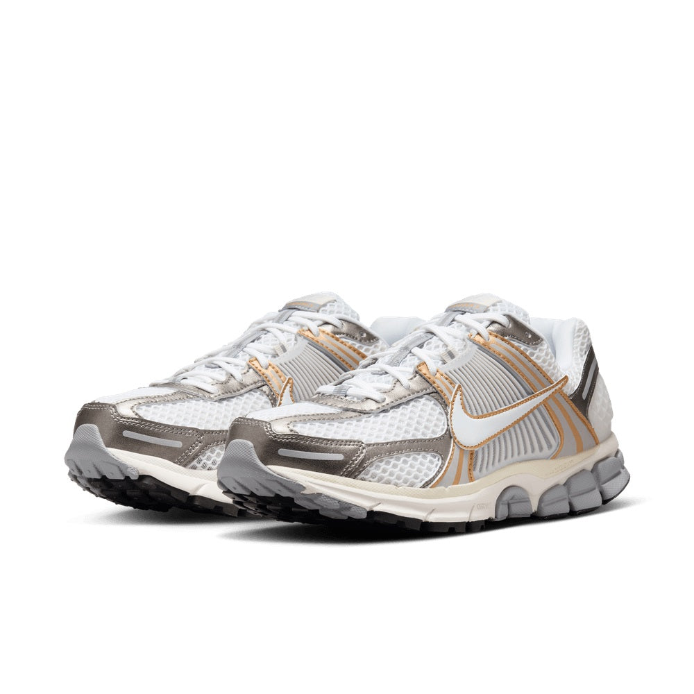 White and gray running sneaker with gold stripe accents and lace-up front, cushioned sole