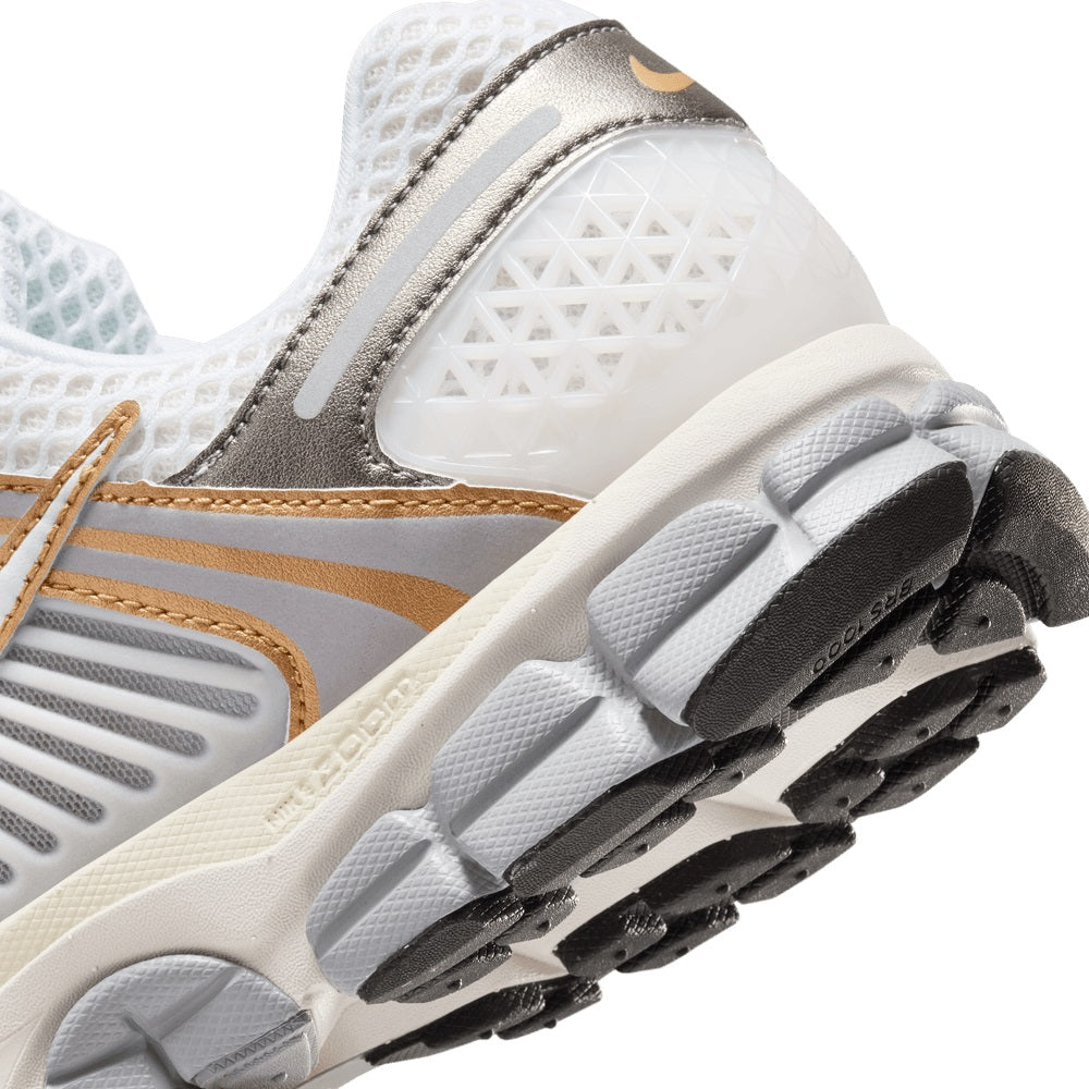 Close-up of textured outsole with gray tread and cream midsole on white upper
