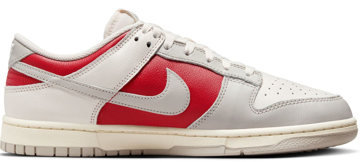 White and red Nike Dunk Low lace-up sneakers, side view with swoosh logos