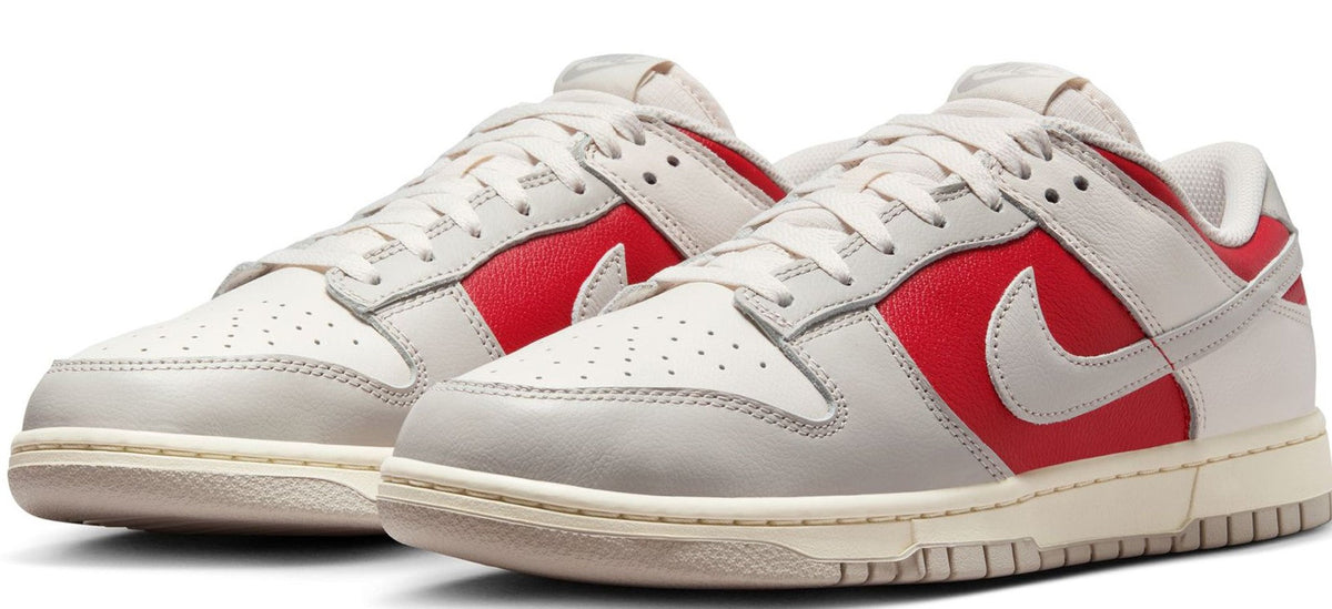 White Nike Dunk Low sneakers with red swoosh panels and lace-up front