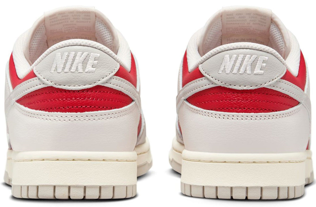 Nike Dunk Low heel pair in white with red accents and NIKE logo on back