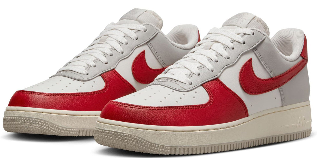 Pair of low-top Nike Air Force 1 sneakers in white and red, lace-up style