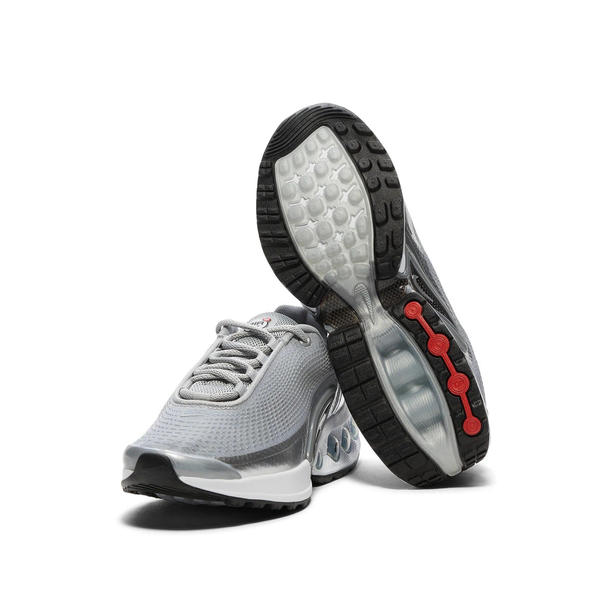 Silver Nike Air sneaker showing treaded outsole with red traction pods