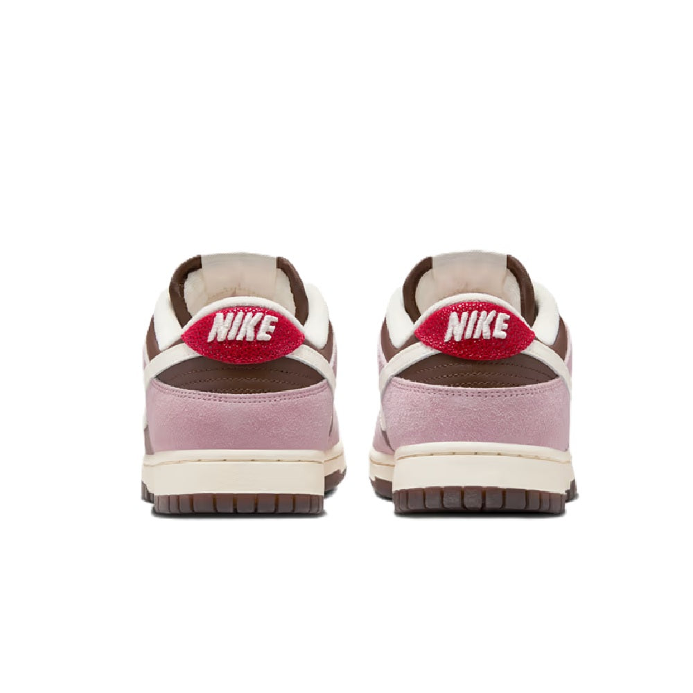 Nike Dunk Low heels, mauve-pink uppers with white trim and red NIKE logo on back