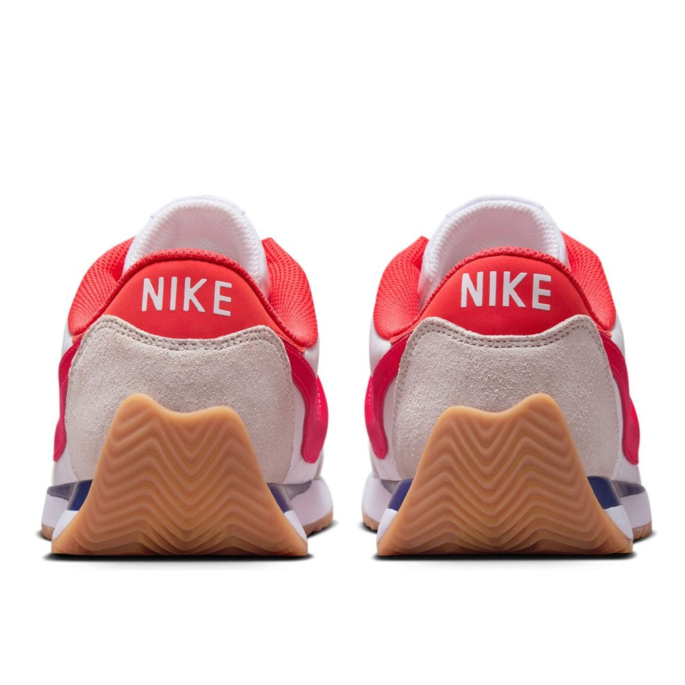 Nike women's sneakers with red heel lining, beige back panels, Nike logo, gum sole