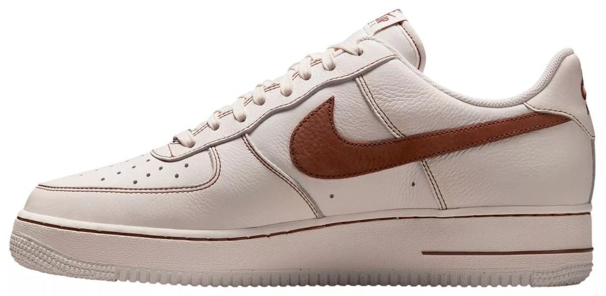 Ivory leather-look sneaker with brown Swoosh stripe, lace-up, and side stitching