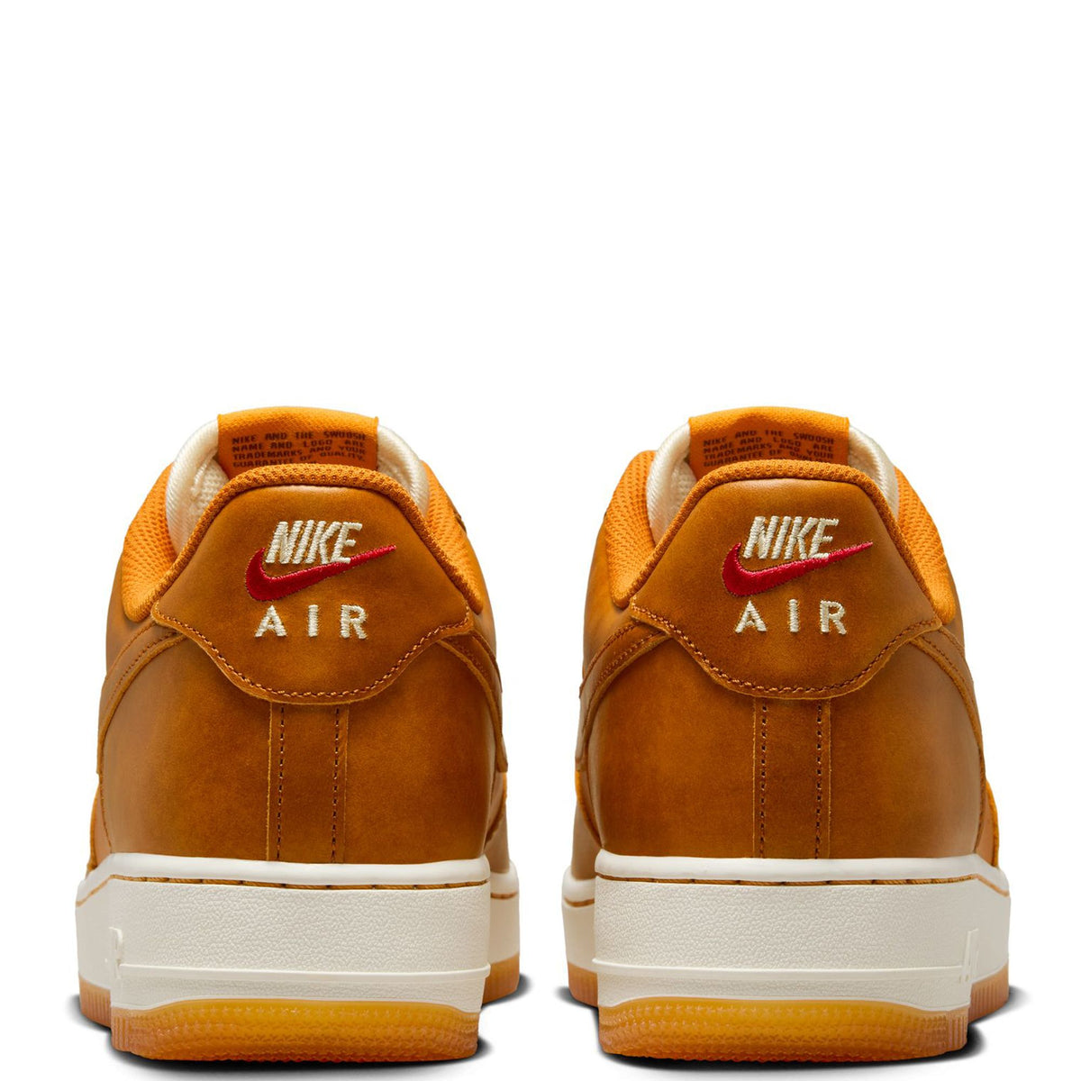 Tan-orange Nike sneakers rear view with white midsoles and red Air branding on heel