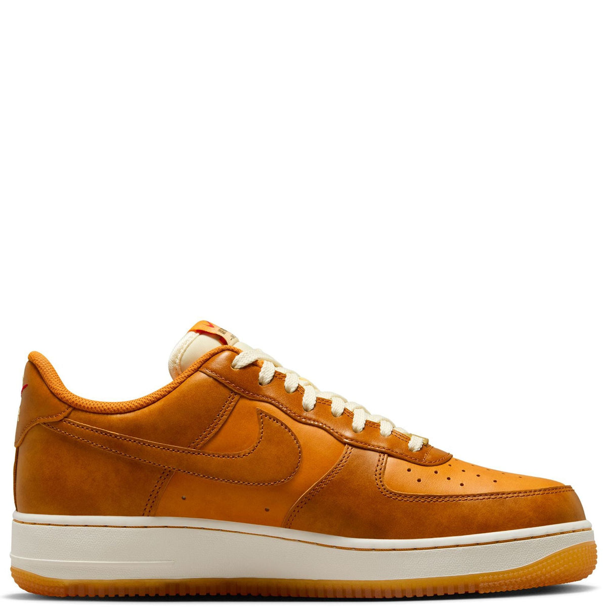 Tan-orange suede low-top sneakers with white laces, swoosh logo, and white rubber sole