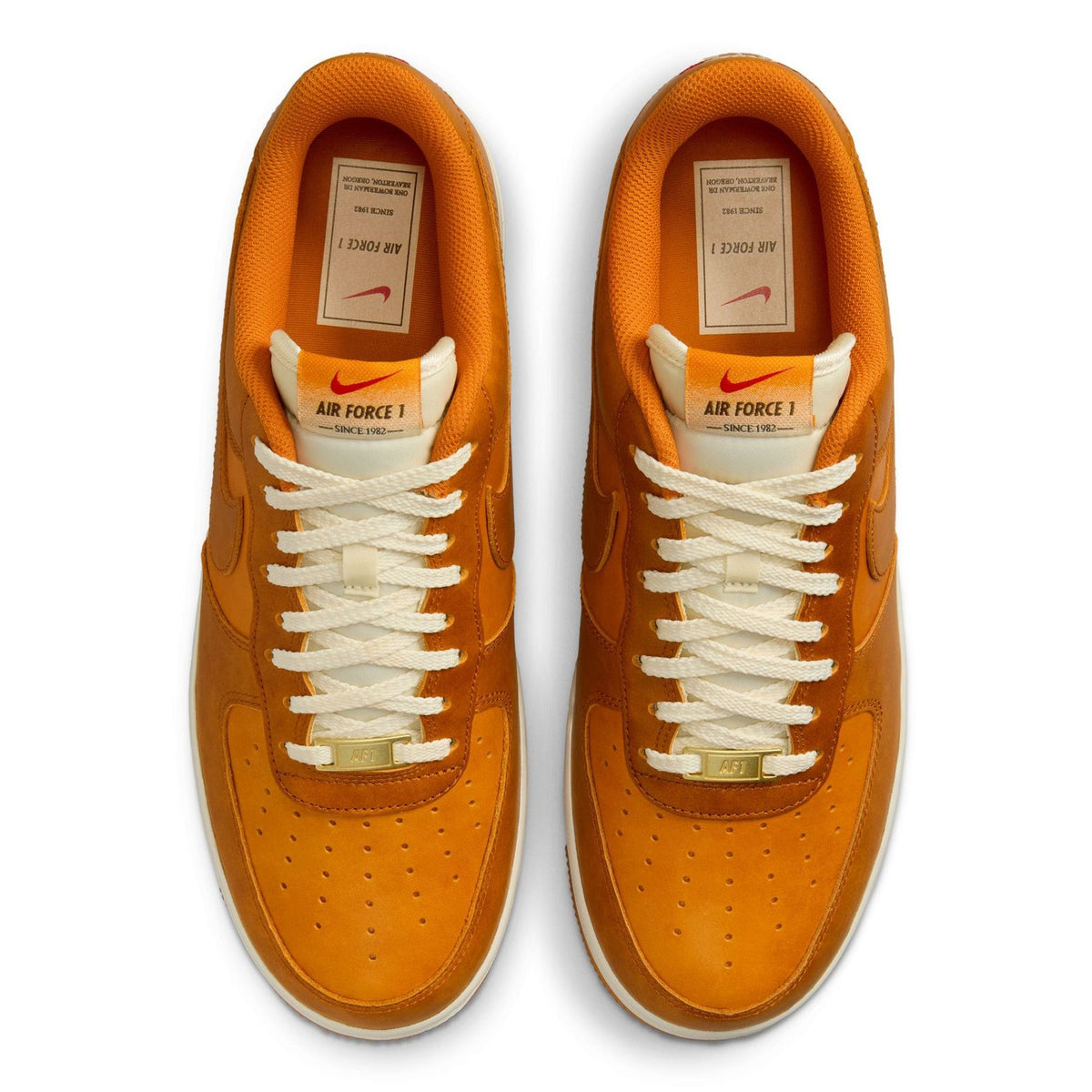 Tan-orange suede sneakers viewed from top with white laces and tongue label details