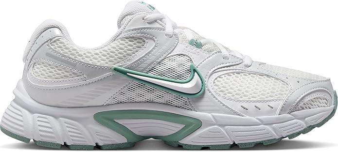 White athletic sneakers with green trim, mesh panels, and cushioned sole