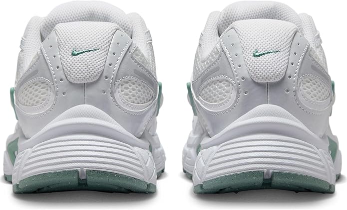 White sneakers with green heel detail, cushioned back, and lace-up eyelets