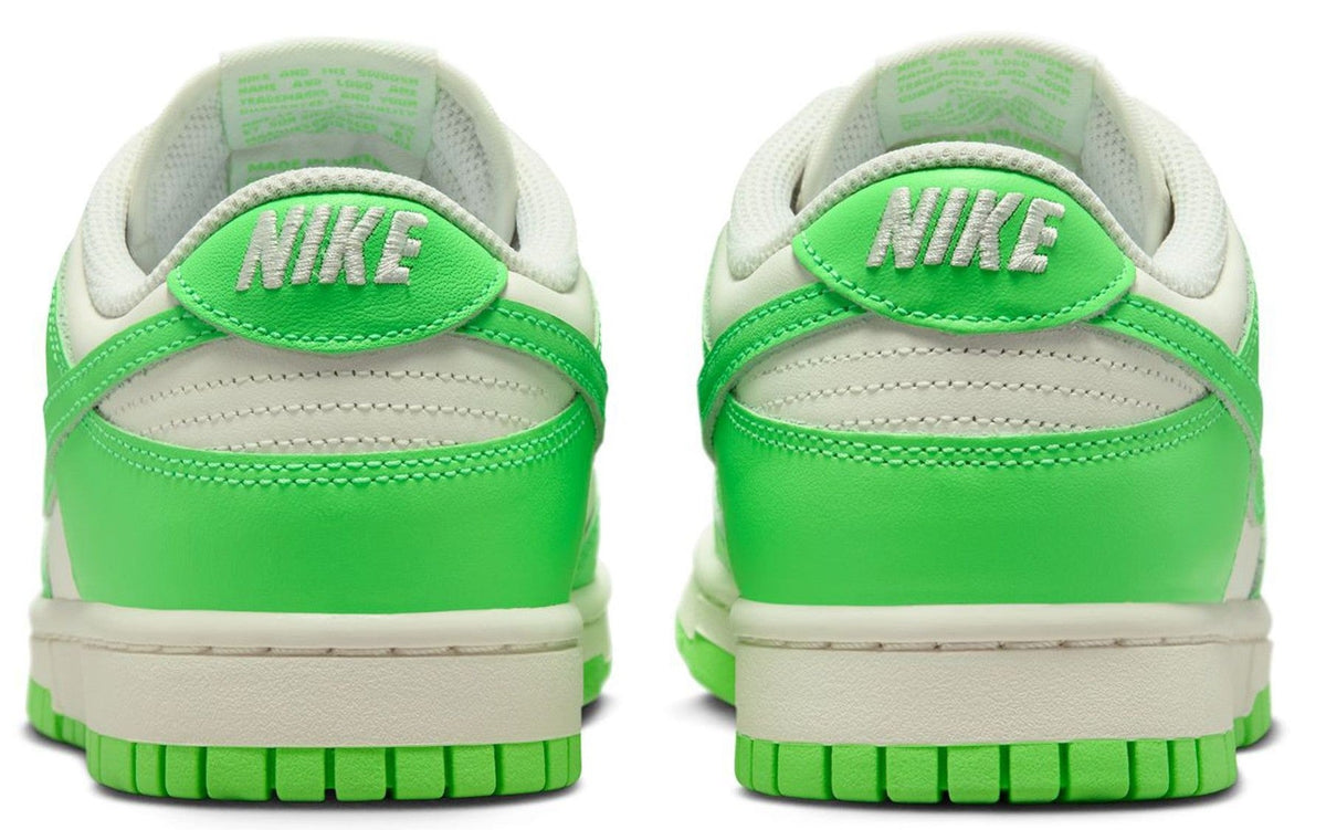 Women’s Nike Dunk Low sneakers, rear view with green heel panels and Nike logo on back tabs.