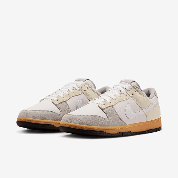 Nike Dunk Low sneakers, front three-quarter view, off-white and gray overlays with gum sole