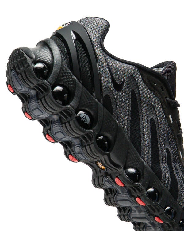 Men's Nike Air Max DN8 SE sneakers, close-up tread and black air pods with red accents