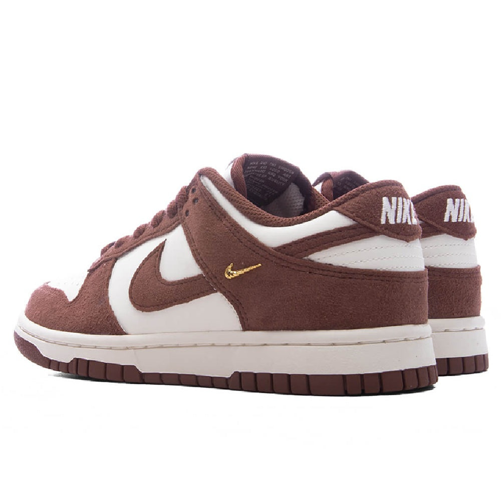 Nike Dunk Low sneakers with brown heel tabs, white mid-panels, and gold swoosh