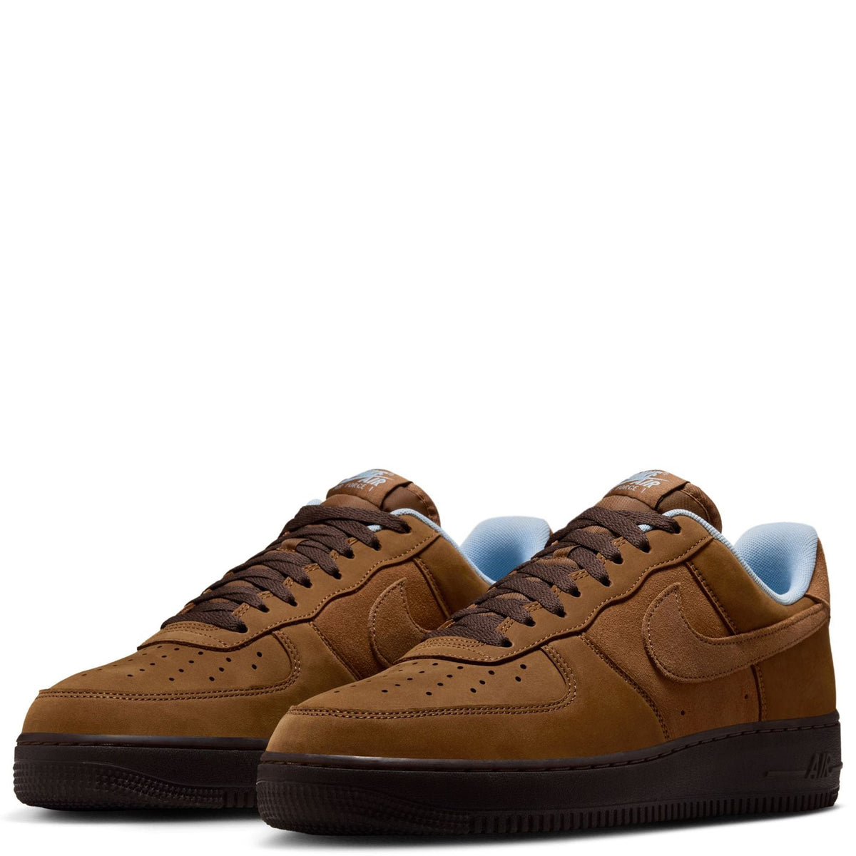 Pair of tan Nike Air Force 1 sneakers, blue heel lining, lace-up with stitched panels.