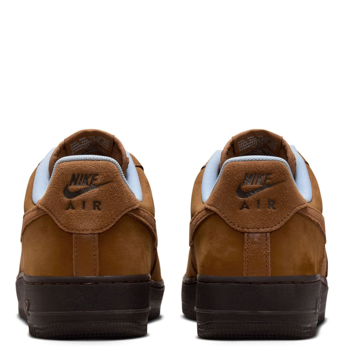 Back view of Nike Air Force 1 sneakers in tan suede, with Nike Air heel logo.