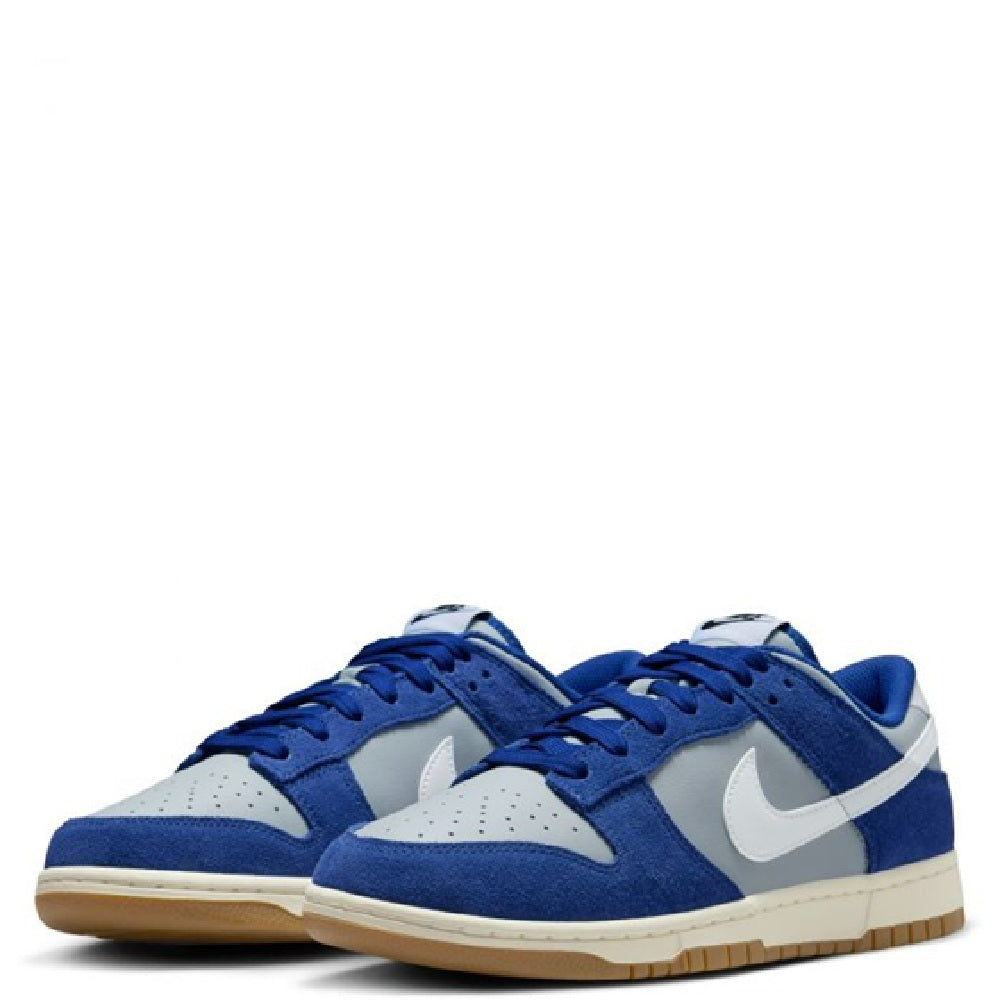 Pair of blue low-top sneakers with white swoosh accents and gum outsole