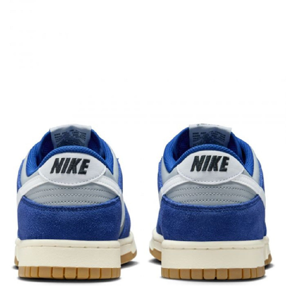 Back view of blue and white low-top Nike sneakers with padded heel and gum sole