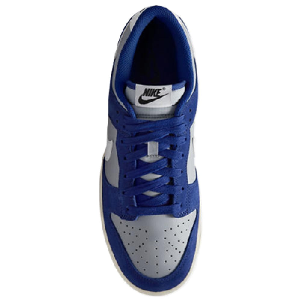 Side view of blue and white low-top sneaker with lace-up design and Nike tongue logo