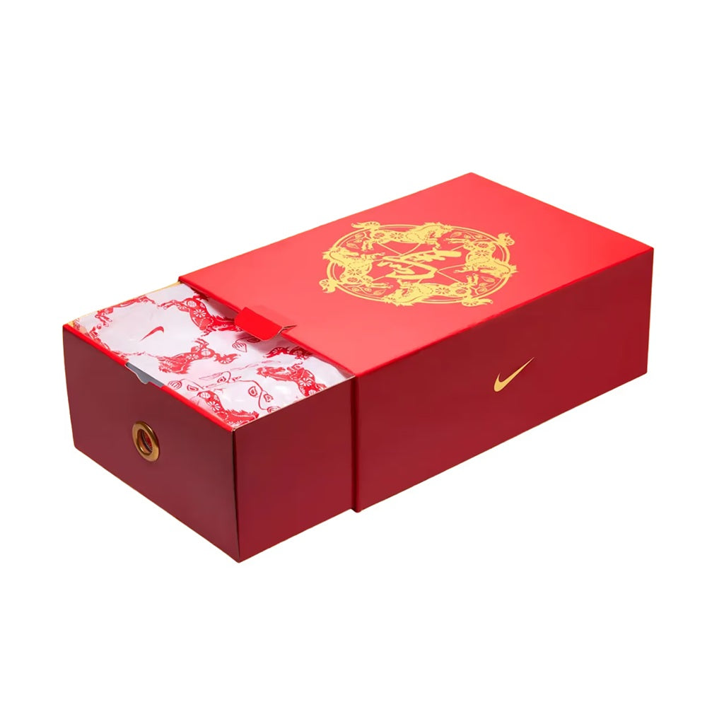 Red Nike shoe box with gold graphic and swoosh, lid partially open