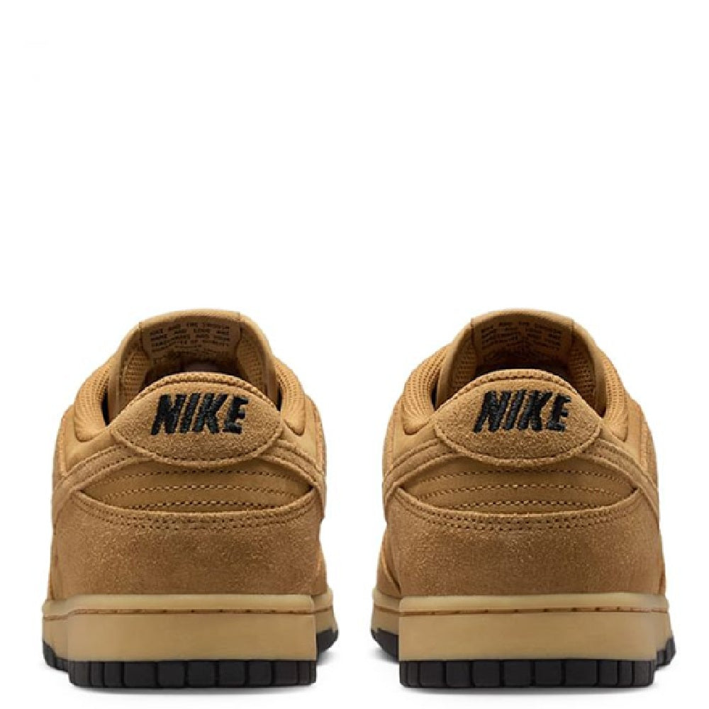 Nike Dunk Low sneakers heel view, tan suede with Nike logo tab and black rubber sole.