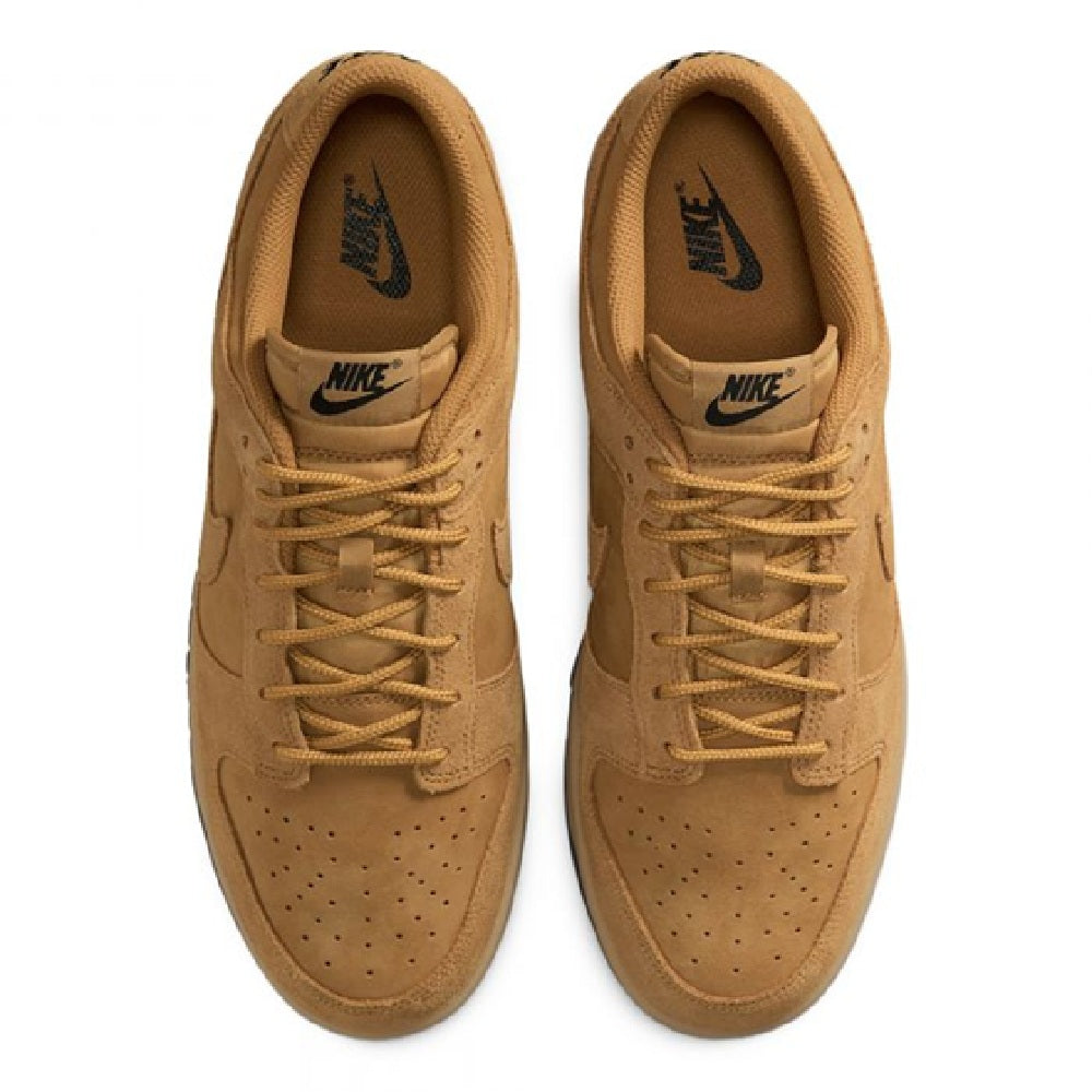 Nike Dunk Low sneakers with tan laces, suede toe perforations, and Nike tongue logo.