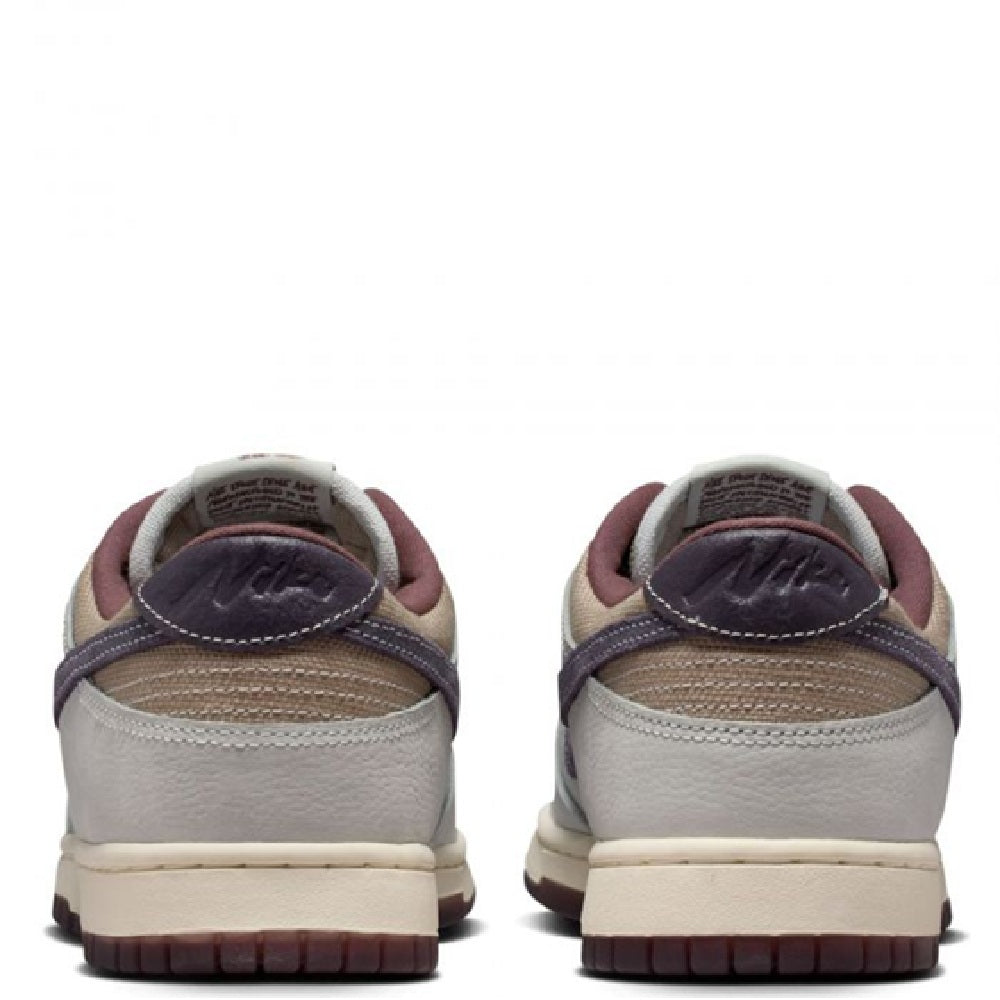 Nike Dunk Low Retro SE sneakers with off-white leather, maroon heel lining, padded collar.