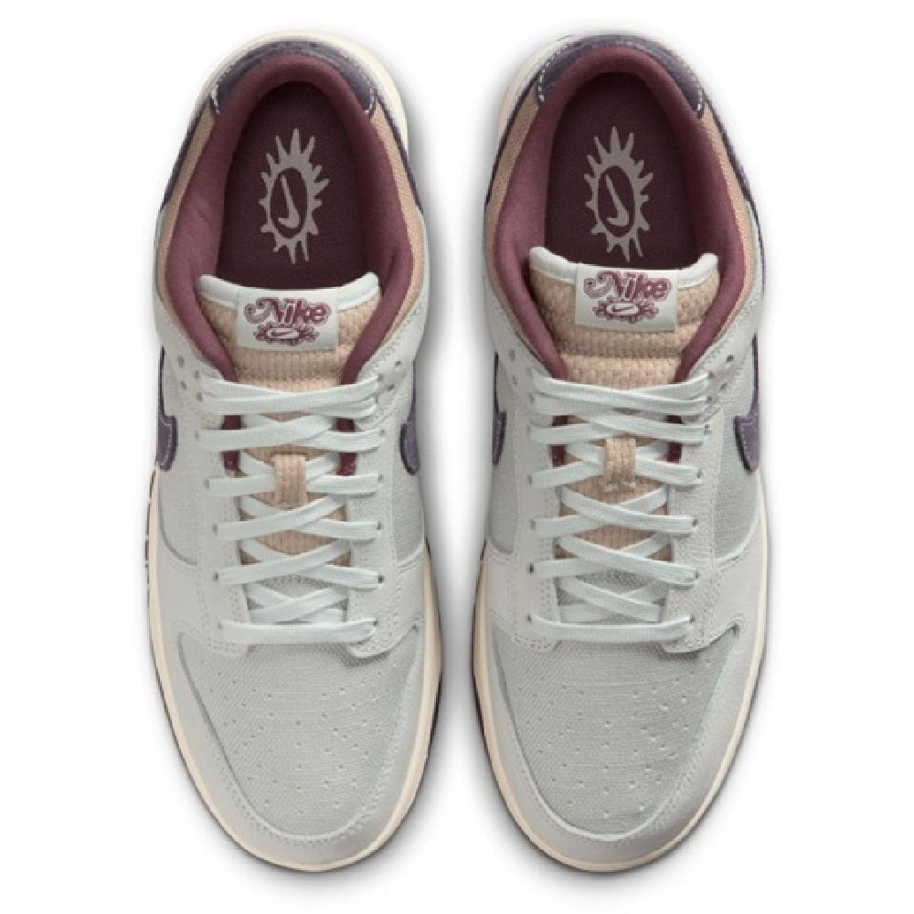 Nike Dunk Low Retro SE sneakers, off-white tongue with logo patch and maroon lining.