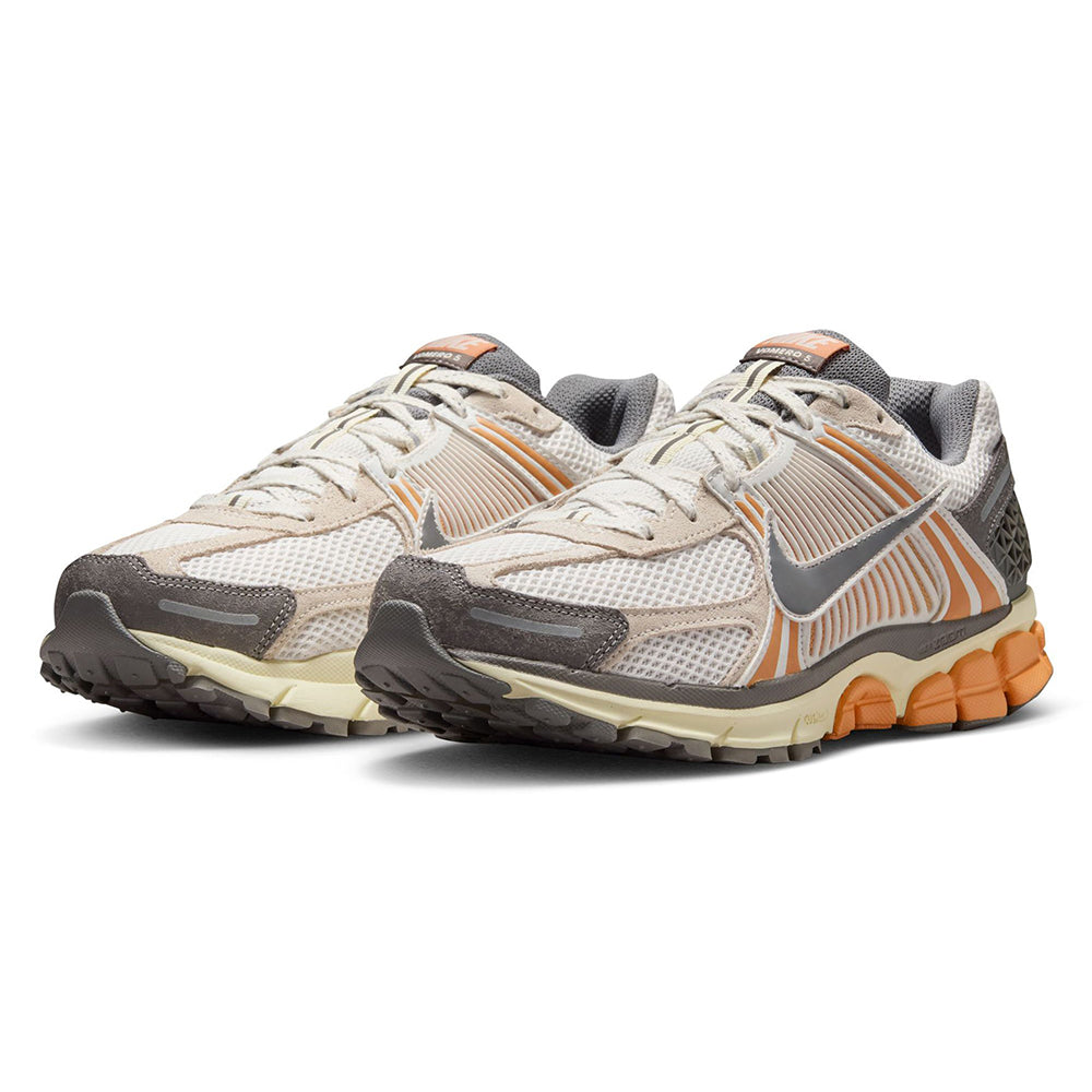 Nike Zoom Vomero 5 low-top sneakers with cream uppers, orange stripes, and gray overlays