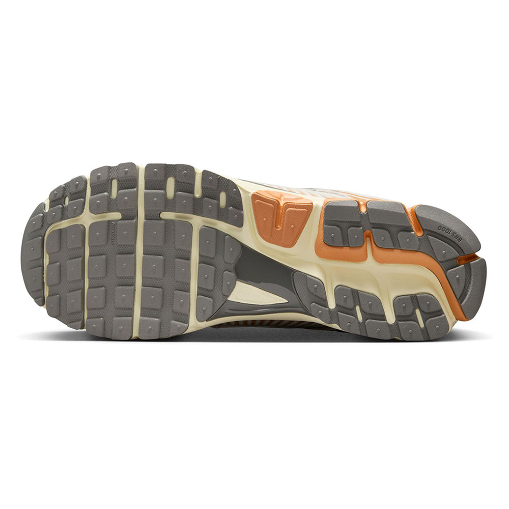 Nike Zoom Vomero 5 outsole view with rugged tread, gray panels, and orange traction inserts