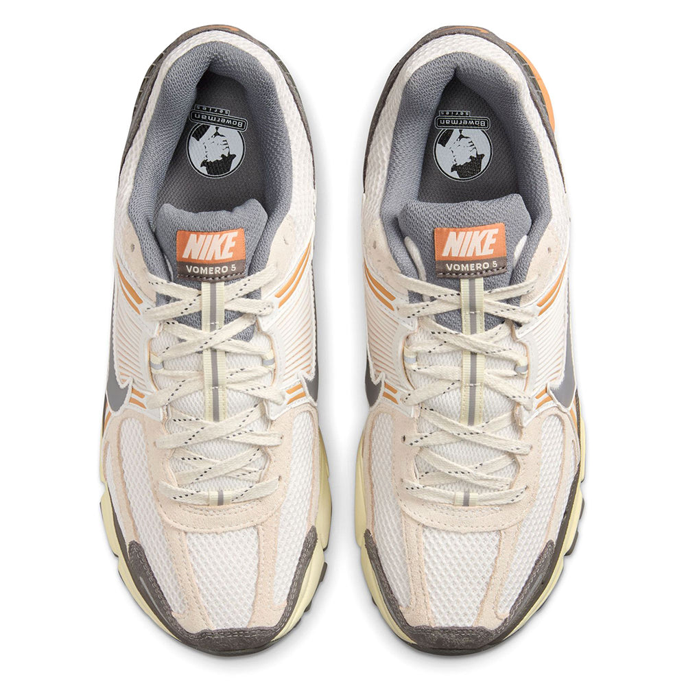 Nike Zoom Vomero 5 front view with white laces, gray tongue, and orange Swoosh accents