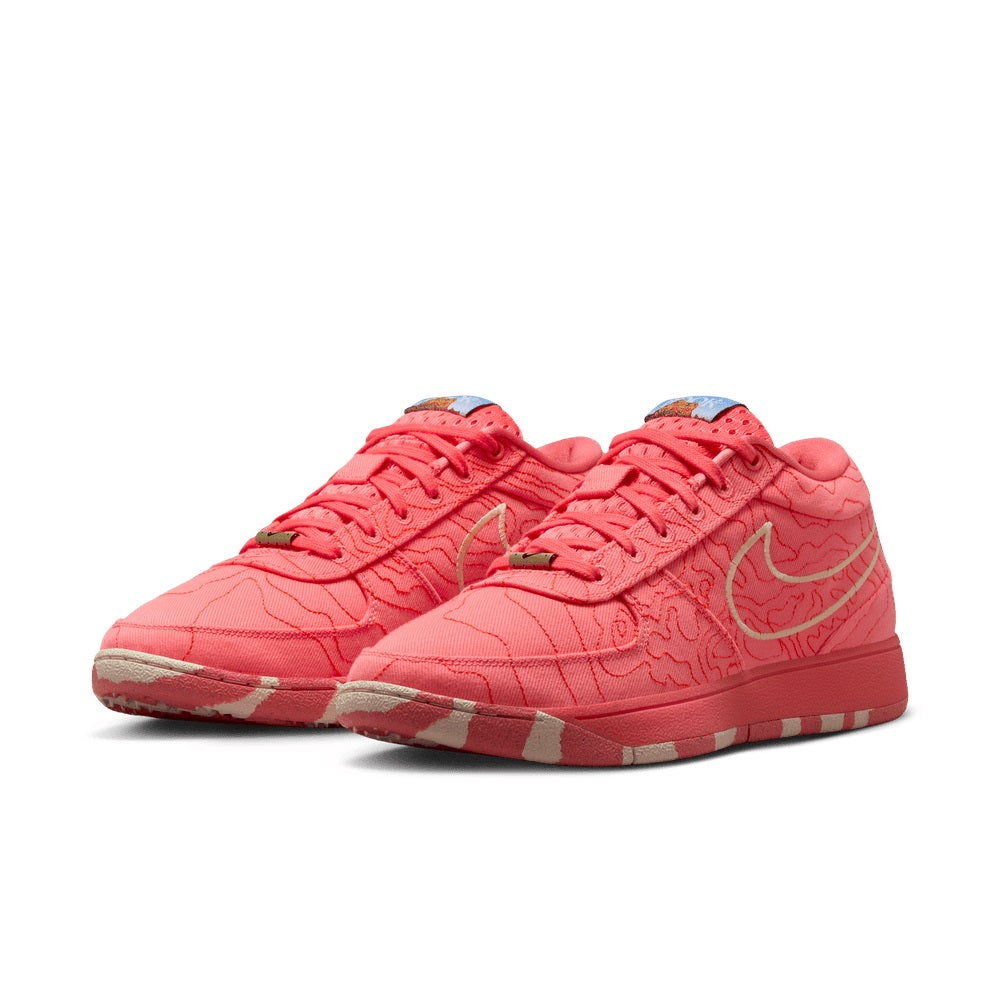 Red men's Nike sneakers, toe and lace area with white Swoosh and patterned upper