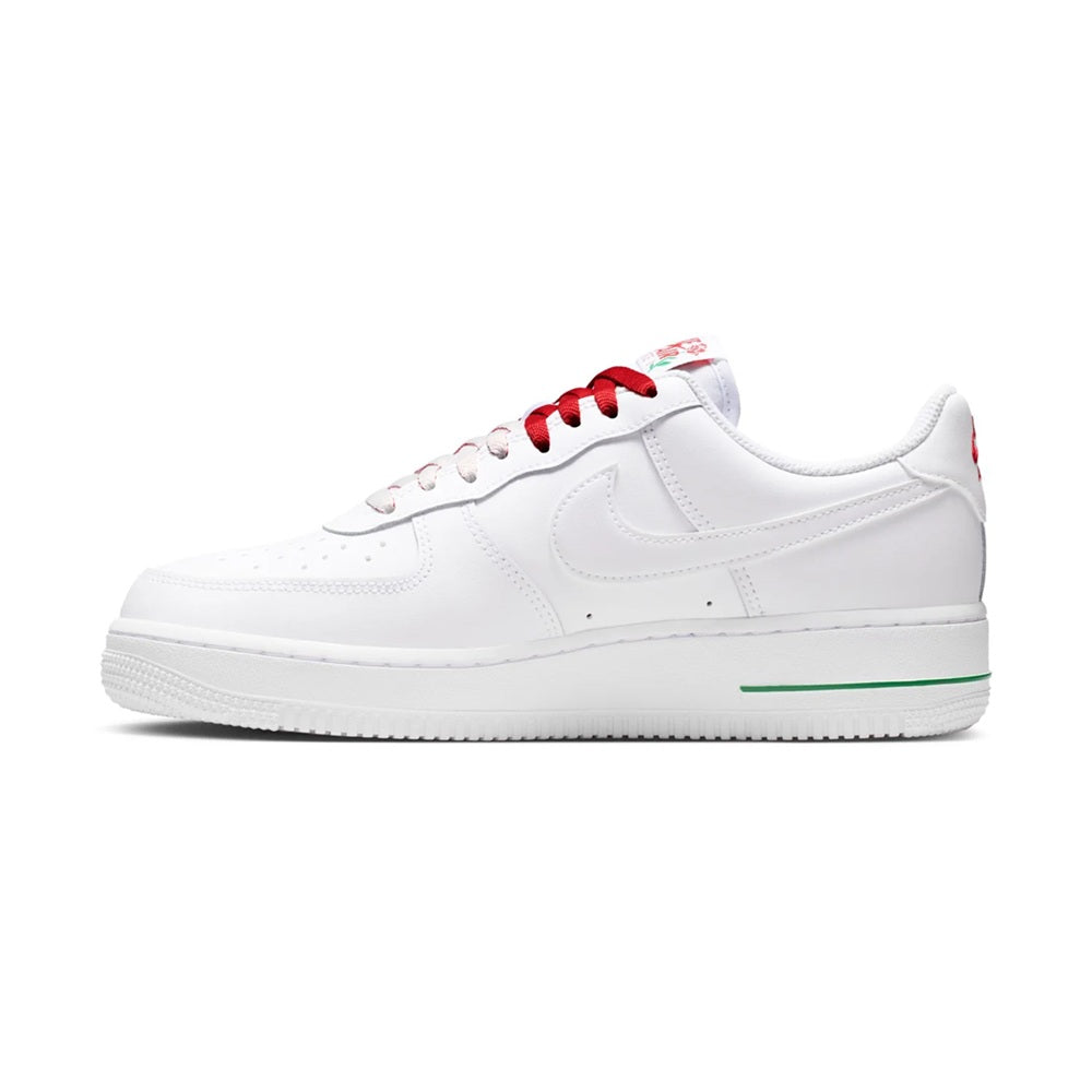 White low-top sneakers, red lace eyelets and swoosh with green accent on midsole
