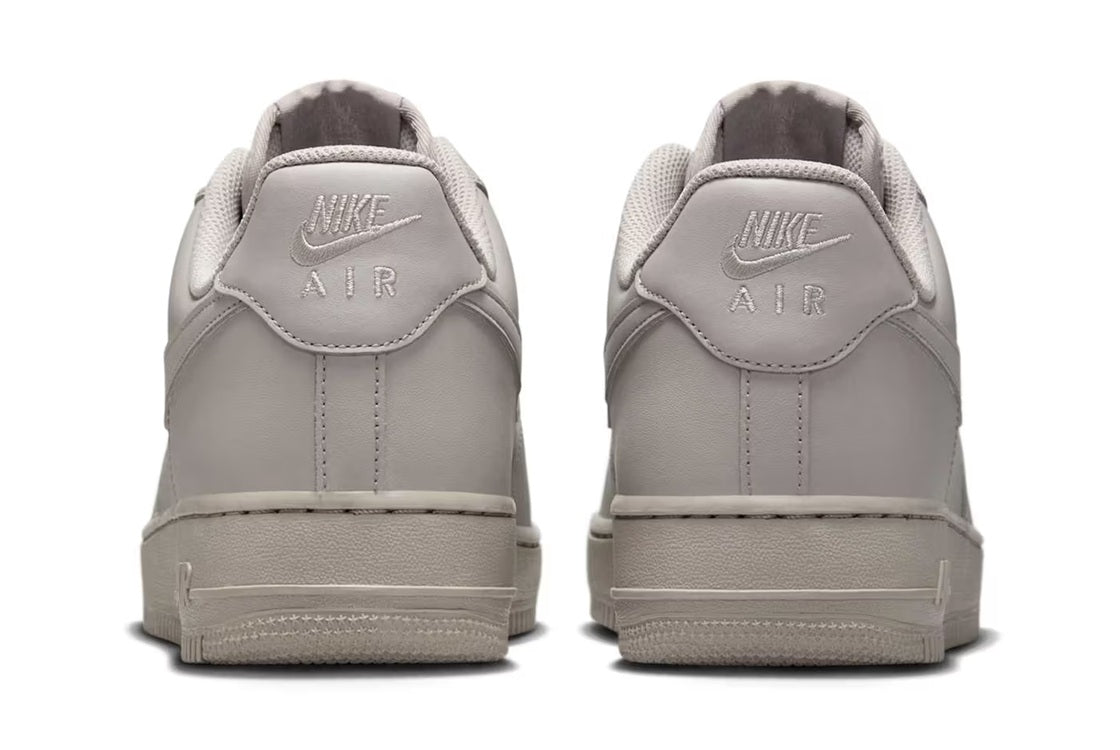 Nike Air Force 1 low-top sneakers, light grey back view with Nike Air heel logo.