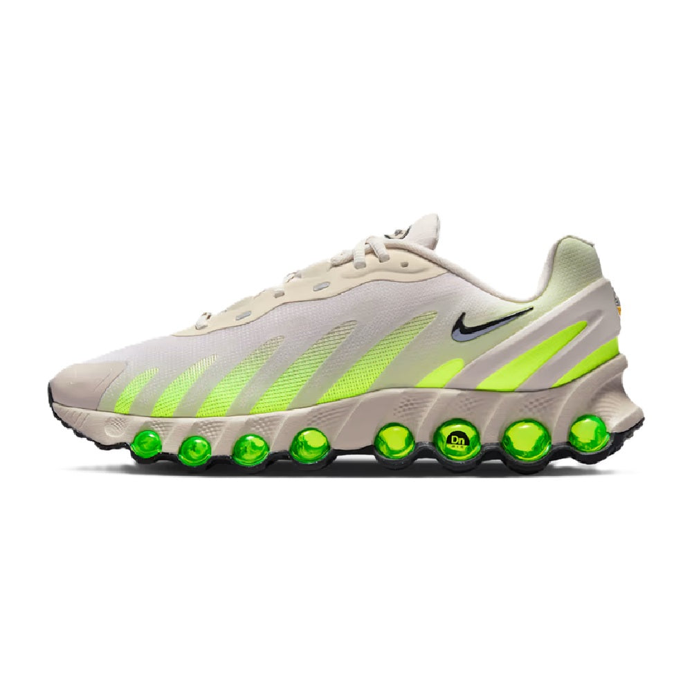 Men's Nike Air Max DN8 sneaker, light brown with black and neon green stripes, green air pods.