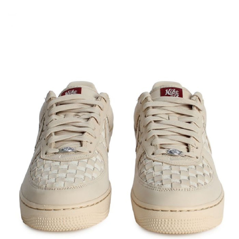 Nike Air Force 1 Low PRM sneakers in pale sand, back view with heel tabs