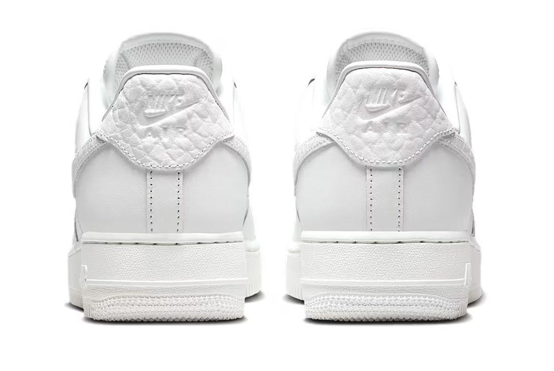 Back view of white Nike Air Force 1 low-top sneakers with heel tabs and branding