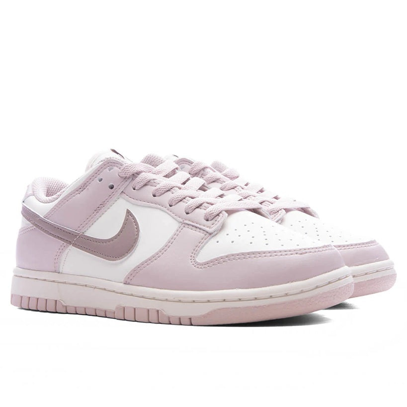 Low-top Nike sneakers with lace-up front, pink leather overlays and white toe box.
