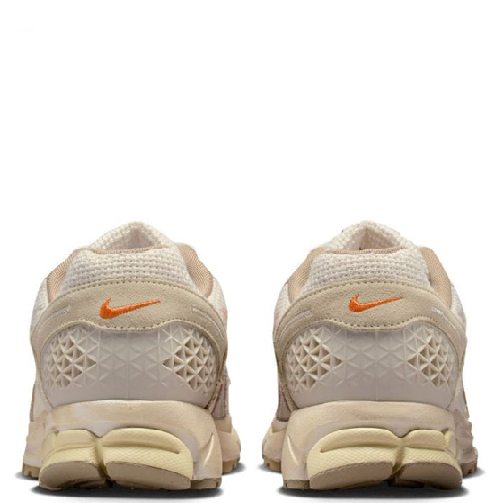 Pair of cream Nike Zoom Vomero 5 LT sneakers from the heel, tan outsole and orange Swoosh