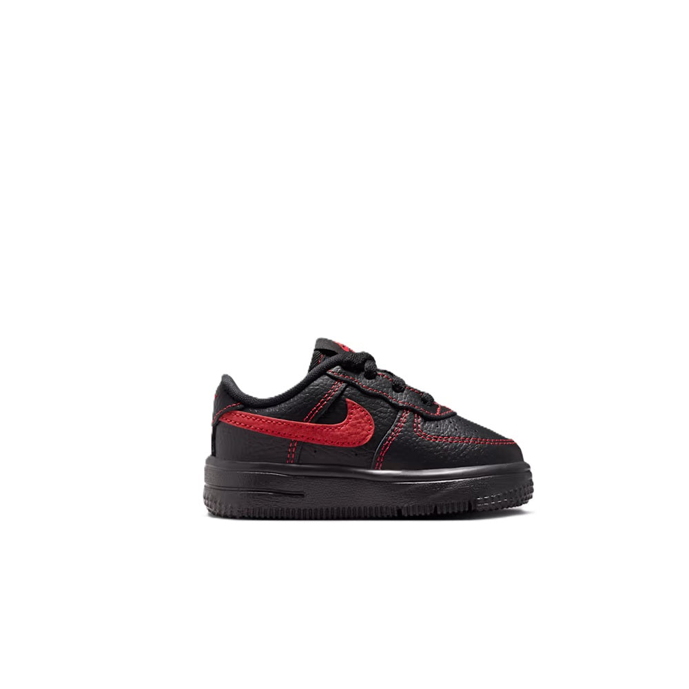 Toddler low-top lace-up sneakers with black leather-look and red swoosh accents.