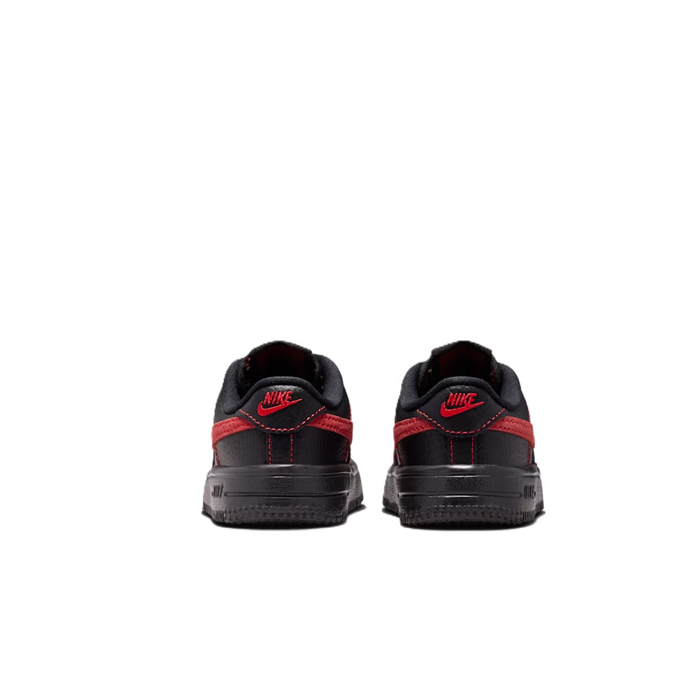 Toddler low-top lace-up sneakers with red heel stripe and Nike logo on back.