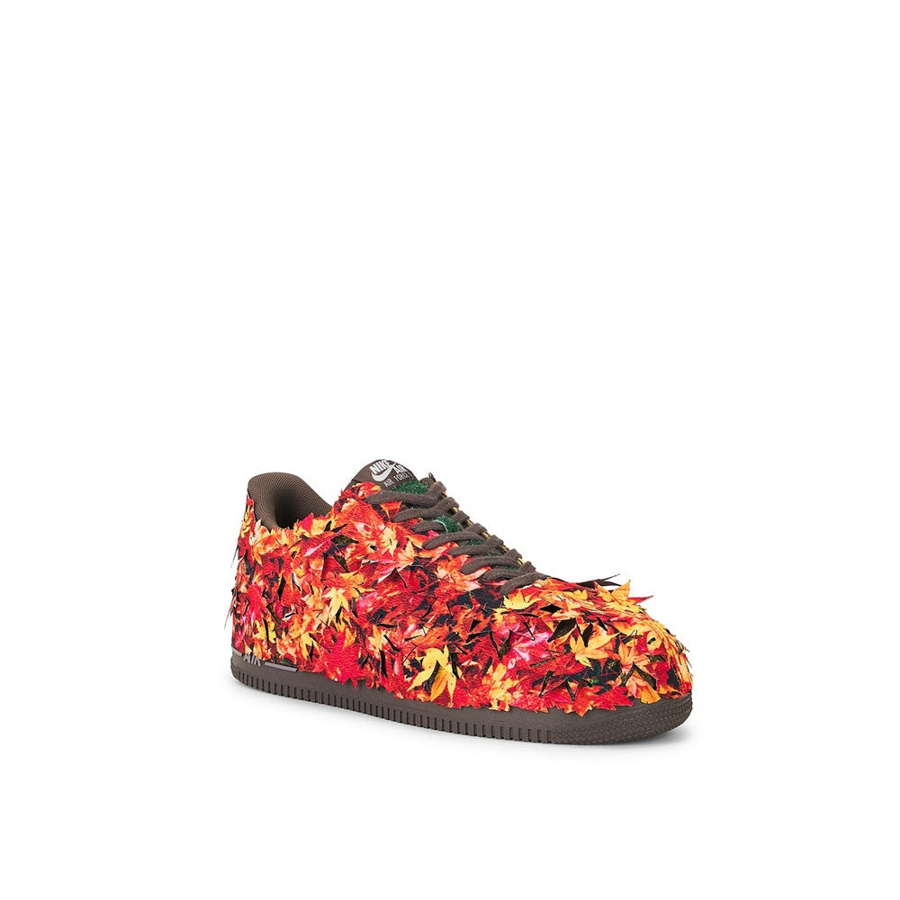 Low-top sneakers with red, orange, and yellow patterned panels and dark lace trim