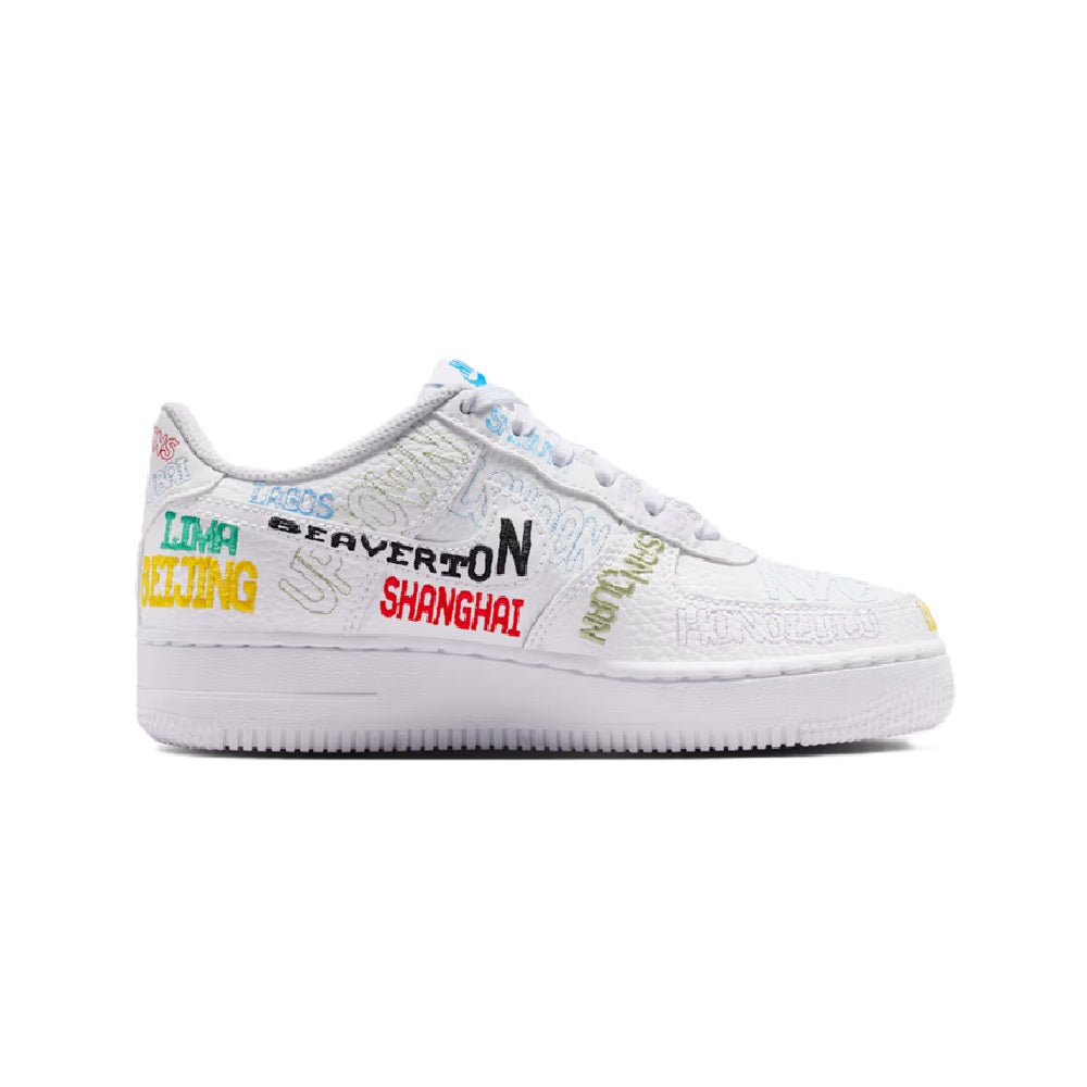White low-top kids sneaker with multicolor text graphics and lace-up front