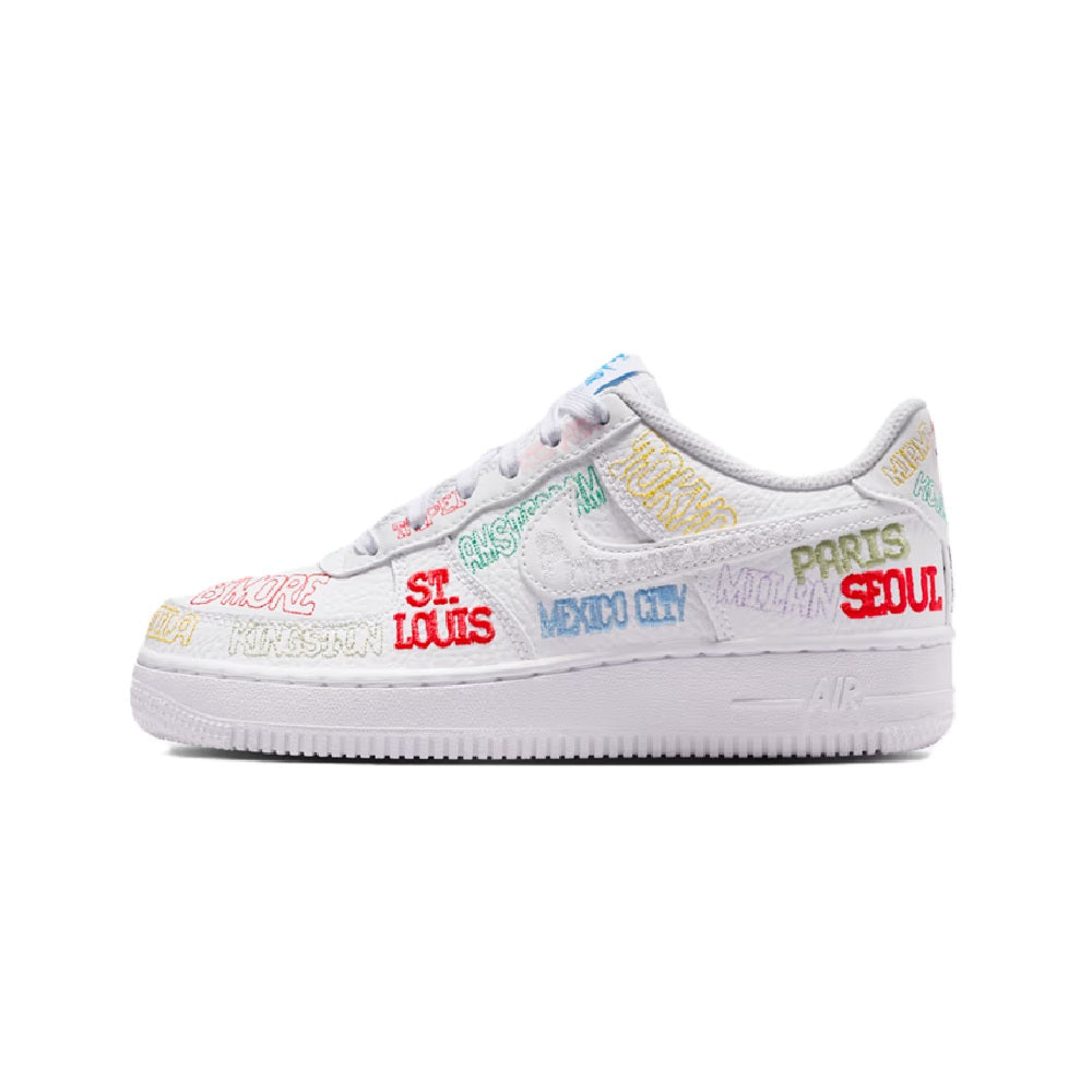 White low-top kids sneaker, side view with multicolor city-style text artwork