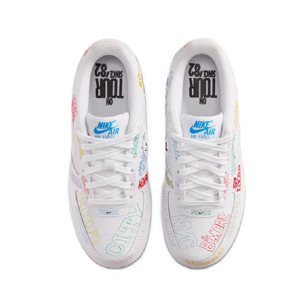 White low-top kids sneaker showing tongue and heel lining with multicolor prints