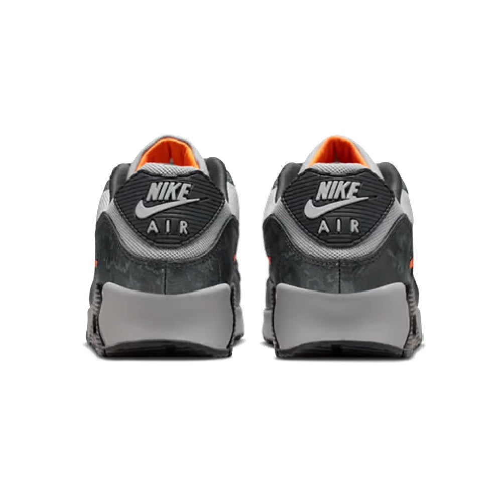 Back view of grey and black sneakers with NIKE Air heel text and orange collar lining